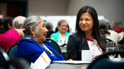 Pam McCoy Jones of SILR (right) to language advocates such as Lynda Minoose, who heads the first Denesųłįné Language and Culture Department on Cold Lake First Nations (left). (Photo credit: John Ulan)